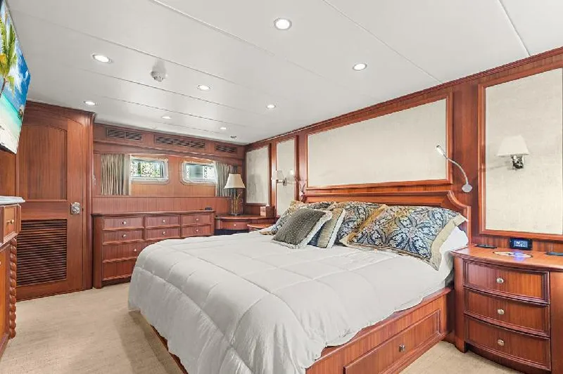 Slide: The Image of Luxurious bedroom in 2006 Paragon Cockpit Motoryacht with elegant wood paneling and plush bedding. - 11
