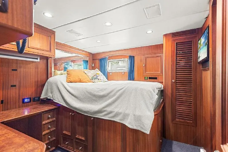 Slide: The Image of Luxurious 2006 Paragon Cockpit Motoryacht bedroom with wood paneling and cozy bedding. - 24