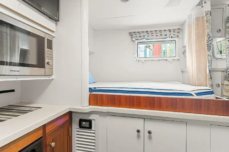Slide: The Image of Interior of 2006 Paragon Cockpit Motoryacht with bed, microwave, and cabinetry. - 26