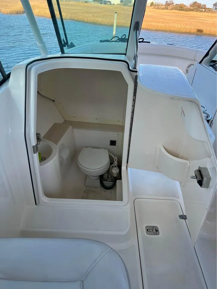 Slide: The Image of 2014 Pursuit DC 265 Dual Console boat on trailer, parked on grass. - 12