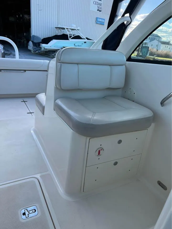 Slide: The Image of 2014 Pursuit DC 265 Dual Console boat interior with cushioned seating and storage. - 21