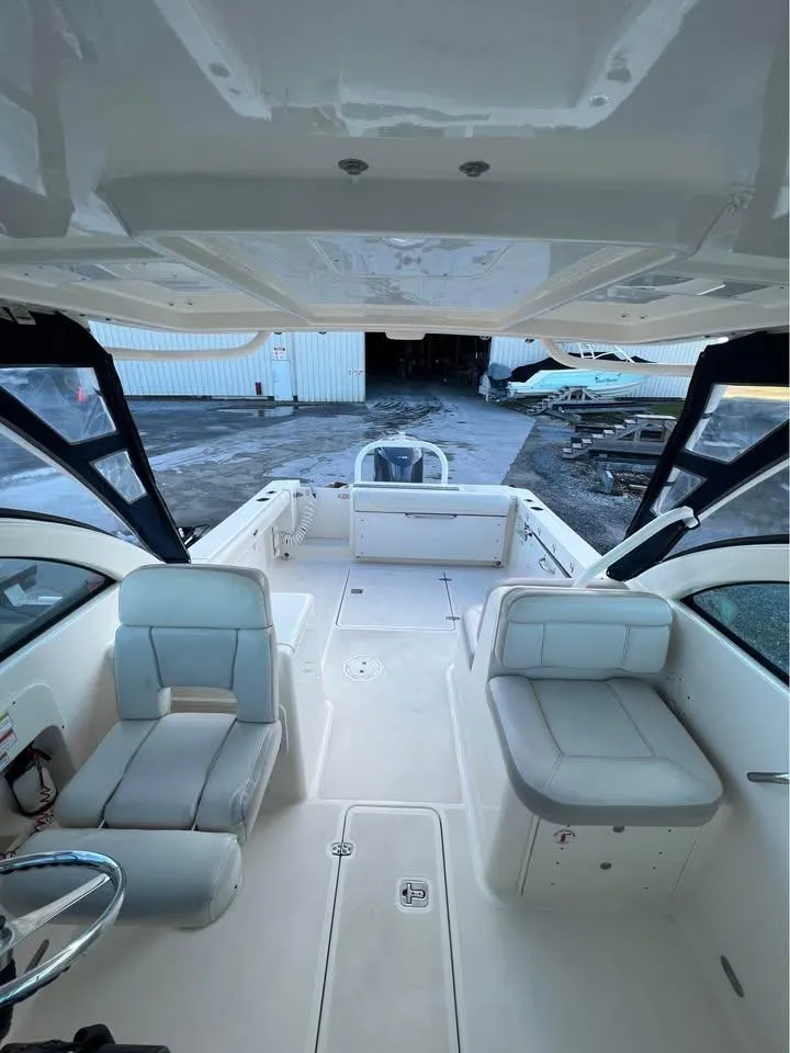 Slide: The Image of 2014 Pursuit DC 265 Dual Console boat interior with seating and steering wheel. - 22