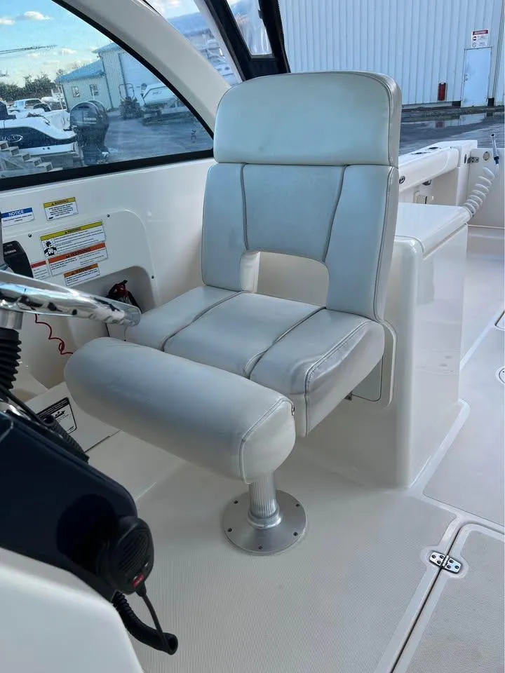 Slide: The Image of 2014 Pursuit DC 265 Dual Console boat interior with white captain's chair. - 23