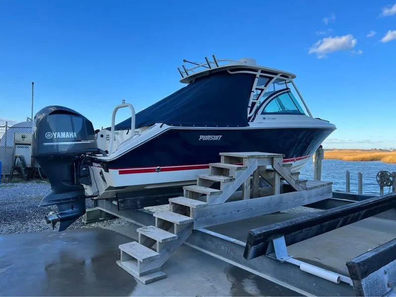 Slide: The Image of 2014 Pursuit DC 265 Dual Console boat with Yamaha engine on dock, clear blue sky. - 3