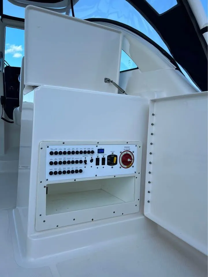 Slide: The Image of 2014 Pursuit DC 265 Dual Console boat with Yamaha outboard motor, parked on grass. - 7