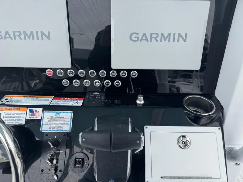 Slide: The Image of 2025 Wellcraft 263 Fisherman dashboard with dual Garmin displays and control panel. - 11
