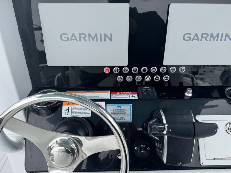 Slide: The Image of 2025 Wellcraft 263 Fisherman dashboard with Garmin displays and steering wheel. - 12