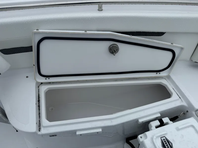 Slide: The Image of 2025 Wellcraft 263 Fisherman storage compartment with open lid, showcasing interior space. - 23
