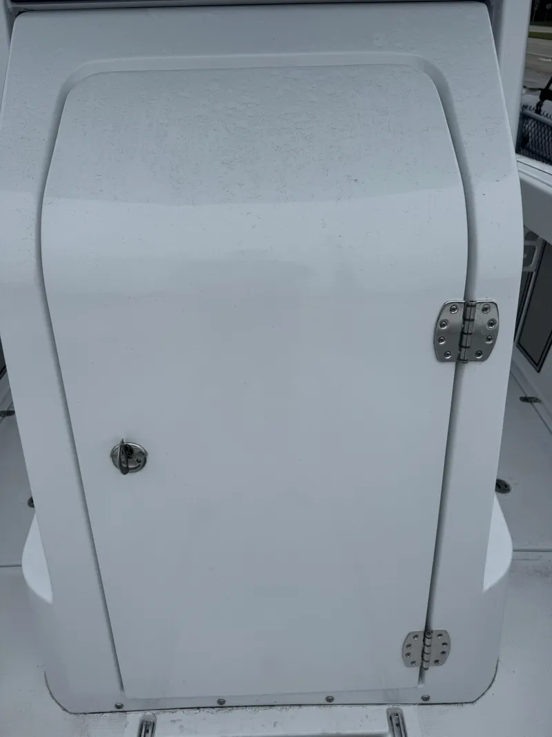 Slide: The Image of 2025 Wellcraft 263 Fisherman boat compartment door with hinges and handle. - 28