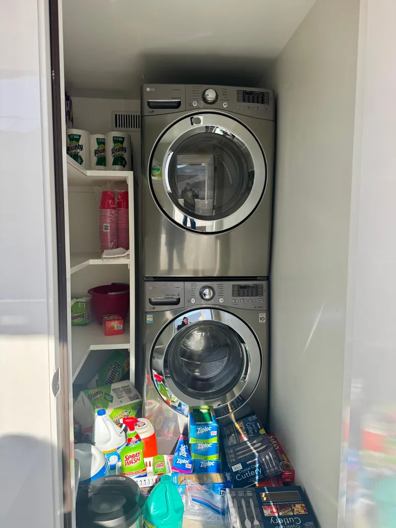 Slide: The Image of Stacked 2017 Adonia KSIX washer and dryer in a laundry room with cleaning supplies. - 18
