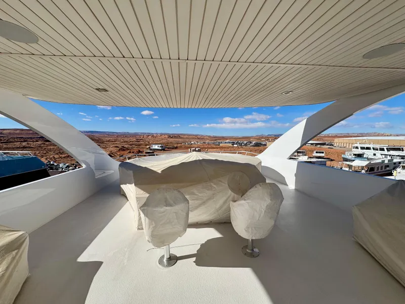 Slide: The Image of Upper deck of 2017 Adonia KSIX yacht with covered seating, overlooking marina and landscape. - 26