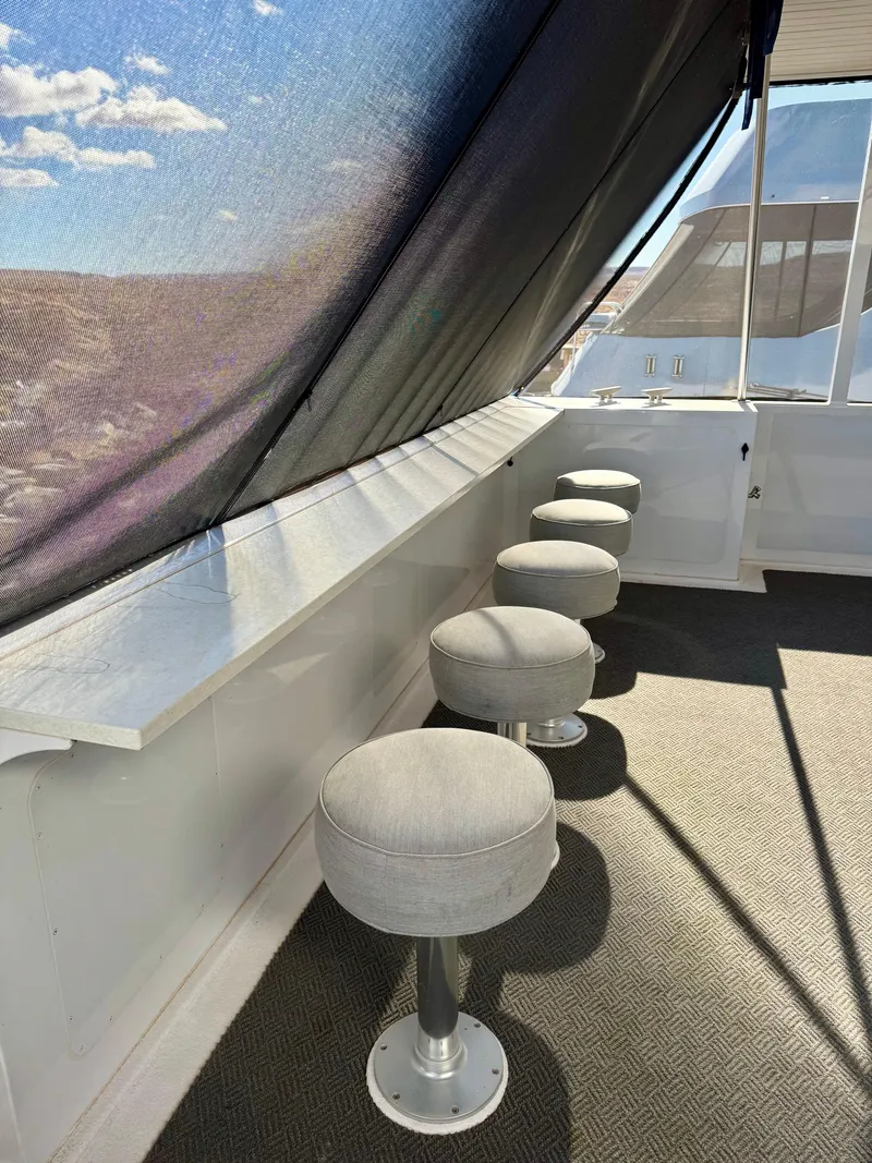 Slide: The Image of 2017 Adonia KSIX boat interior with bar stools and shaded windows. - 29