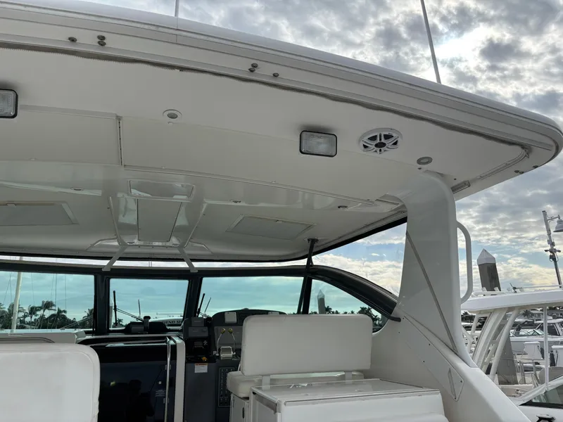 Slide: The Image of 2005 Tiara Yachts 3800 Open cockpit with seating, under a cloudy sky at a marina. - 14