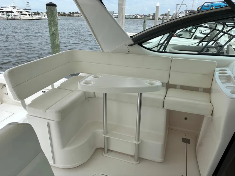 Slide: The Image of 2005 Tiara Yachts 3800 Open interior with white seating and table, docked by the water. - 32