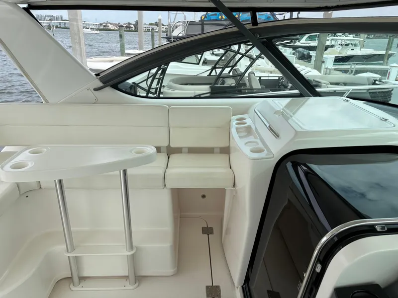 Slide: The Image of 2005 Tiara Yachts 3800 Open interior with white seating and helm, docked at marina. - 33