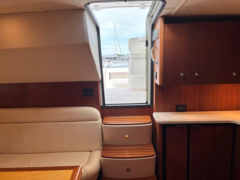 Slide: The Image of Interior of 2005 Tiara Yachts 3800 Open, featuring seating and wooden cabinetry. - 46