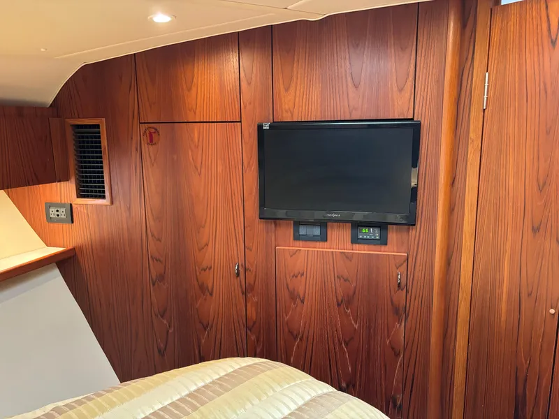 Slide: The Image of Interior of 2005 Tiara Yachts 3800 Open with wood paneling and mounted TV. - 57