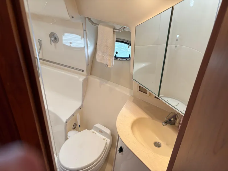 Slide: The Image of 2005 Tiara Yachts 3800 Open bathroom with toilet, sink, mirror, and towel. - 64