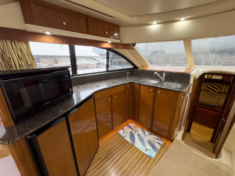 Slide: The Image of Interior of 2006 Meridian 411 Sedan yacht kitchen with wood cabinets and modern appliances. - 18