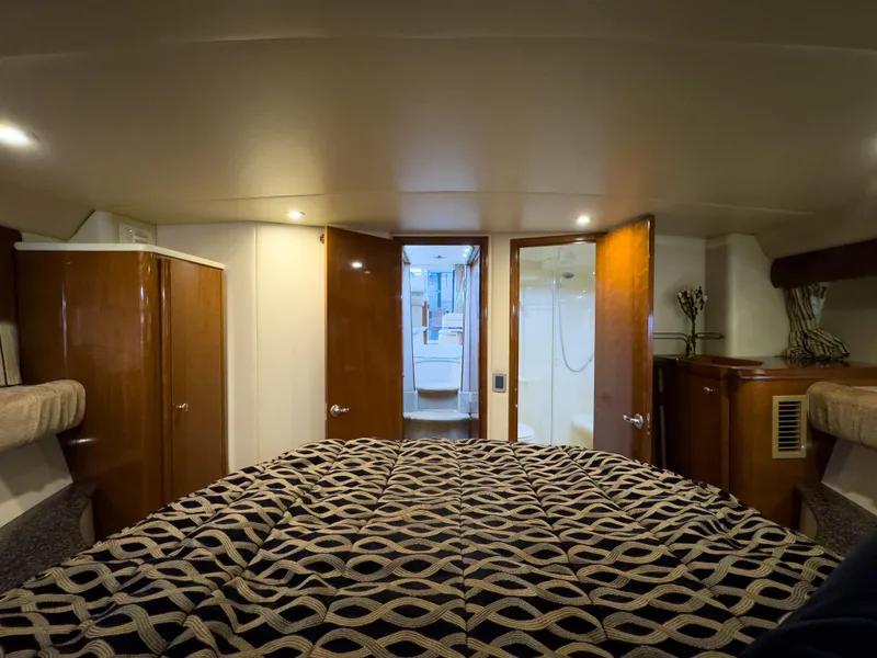 Slide: The Image of Interior of 2006 Meridian 411 Sedan yacht bedroom with patterned bedding and wooden cabinetry. - 19
