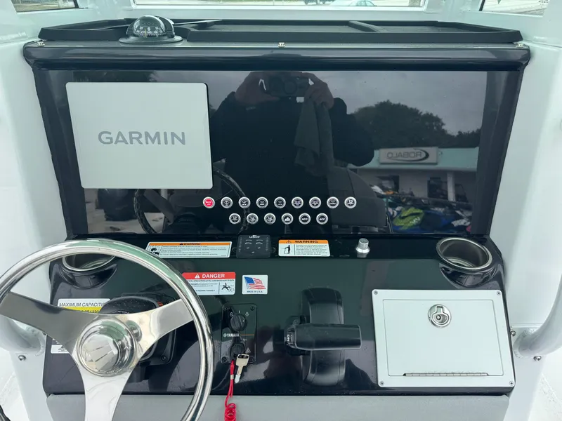 Slide: The Image of 2025 Wellcraft 223 Fisherman dashboard with Garmin navigation system and steering wheel. - 11