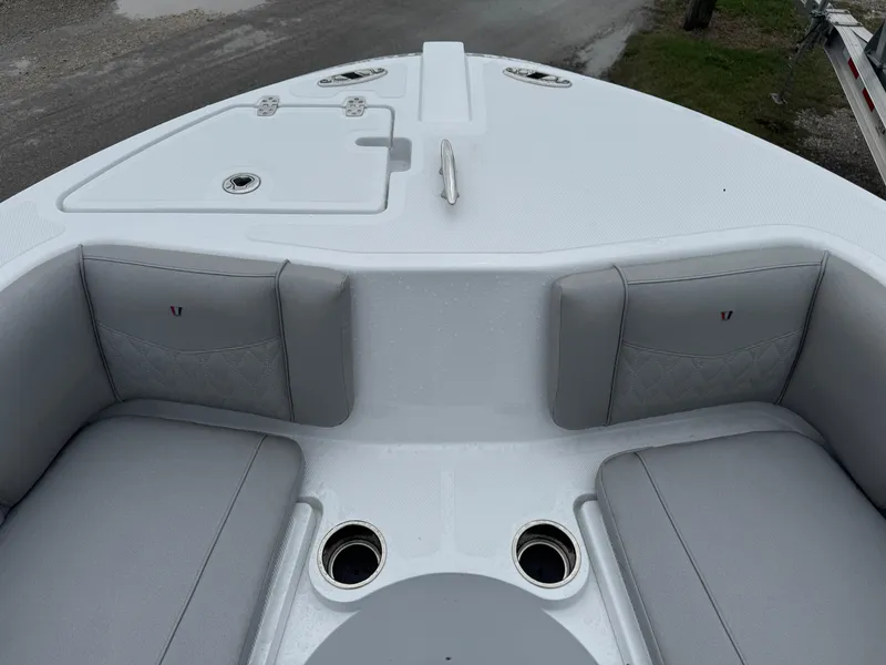 Slide: The Image of 2025 Wellcraft 223 Fisherman boat interior with cushioned seating and cup holders. - 18
