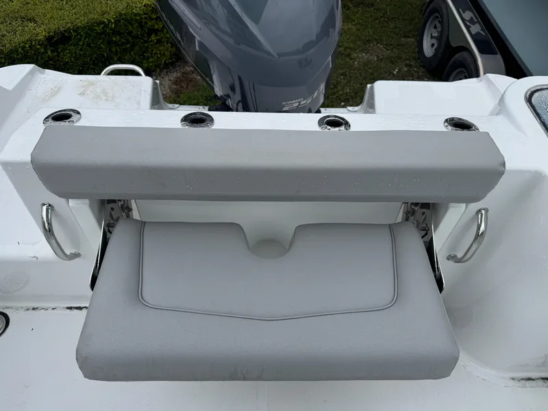 Slide: The Image of 2025 Wellcraft 223 Fisherman boat seat with rod holders and engine in background. - 8