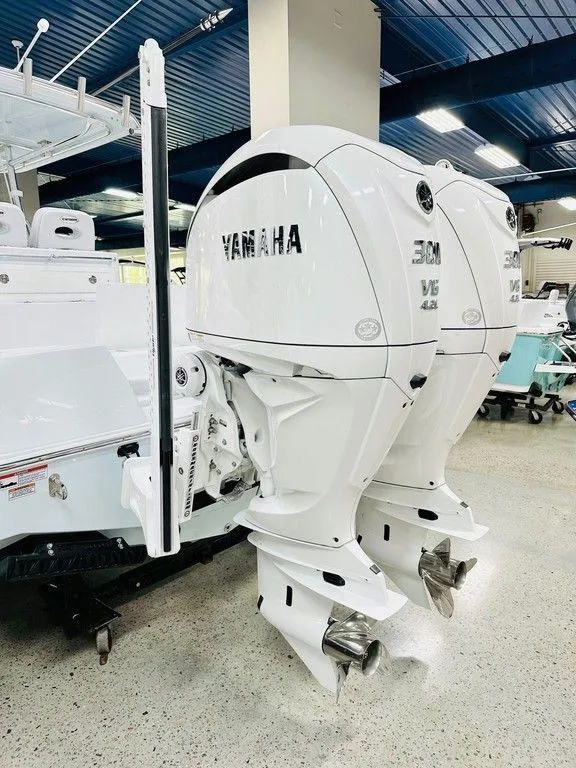 Slide: The Image of 2025 Contender 29BAY boat with dual Yamaha outboard engines in showroom. - 15
