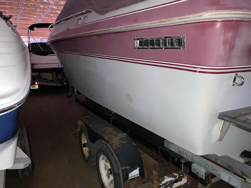 Slide: The Image of 1988 Cobalt 23 boat on trailer in storage, featuring a red and white exterior. - 2