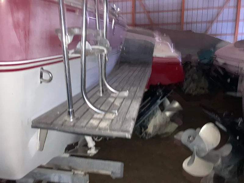 Slide: The Image of 1988 Cobalt 23 boat in storage, featuring a wooden swim platform and metal railings. - 4