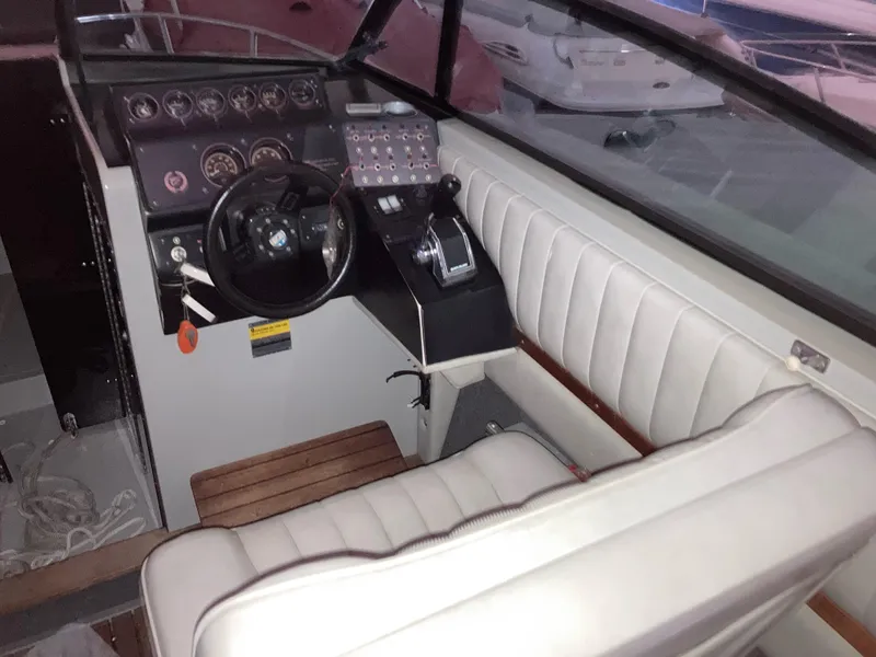 Slide: The Image of Interior of a 1988 Cobalt 23 boat, featuring steering wheel and control panel. - 6