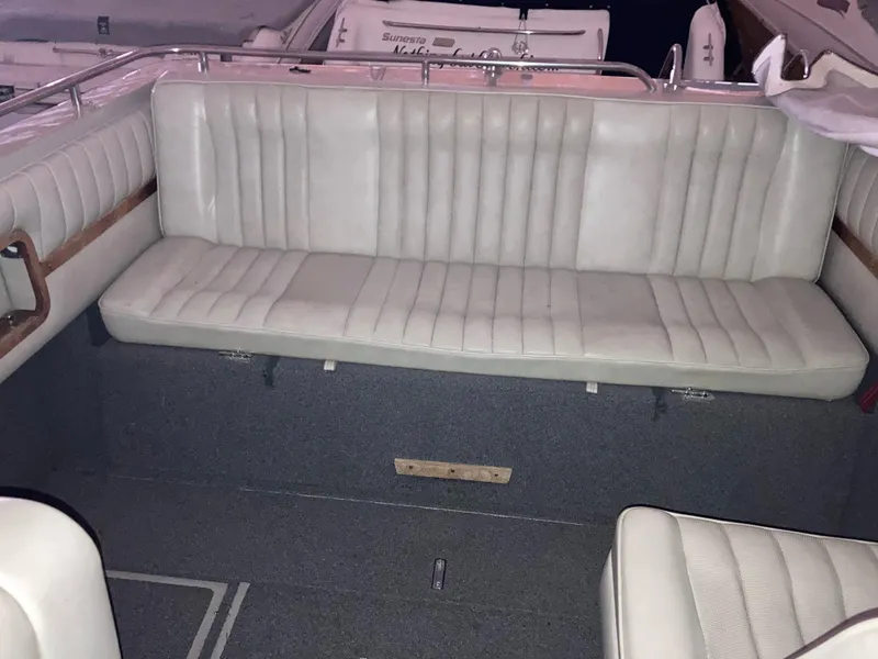 Slide: The Image of 1988 Cobalt 23 boat interior with white cushioned seating and gray flooring. - 7