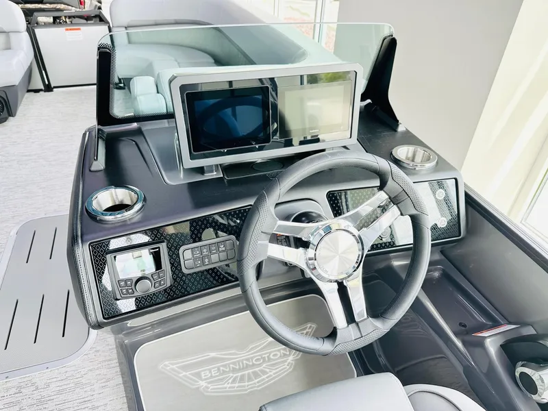 Slide: The Image of 2025 Bennington 24 MSB boat dashboard with steering wheel and digital displays. - 2