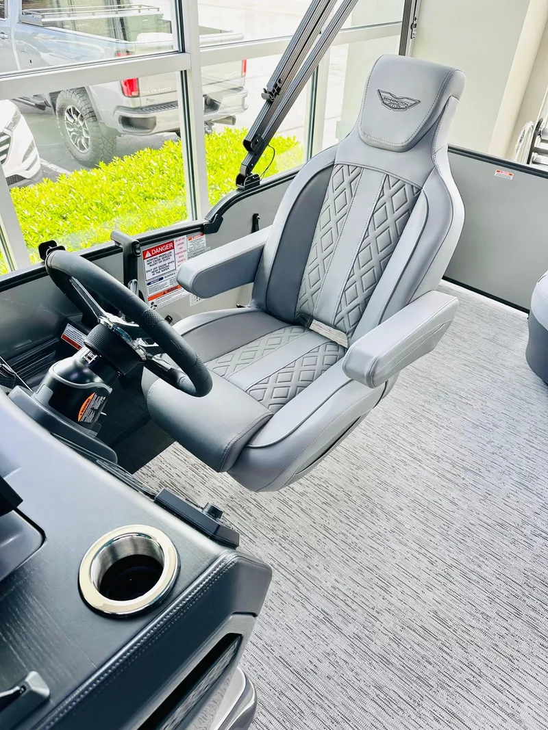 Slide: The Image of 2025 Bennington 24 MSB boat interior with luxury captain's chair and steering wheel. - 4