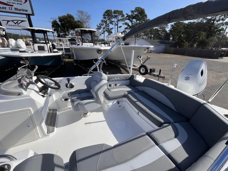 Slide: The Image of 2025 NauticStar 203 SC Deck boat interior with gray seating and steering wheel. - 13
