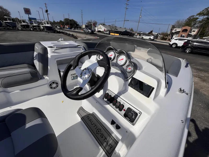 Slide: The Image of 2025 NauticStar 203 SC Deck boat interior with steering wheel and dashboard controls. - 8