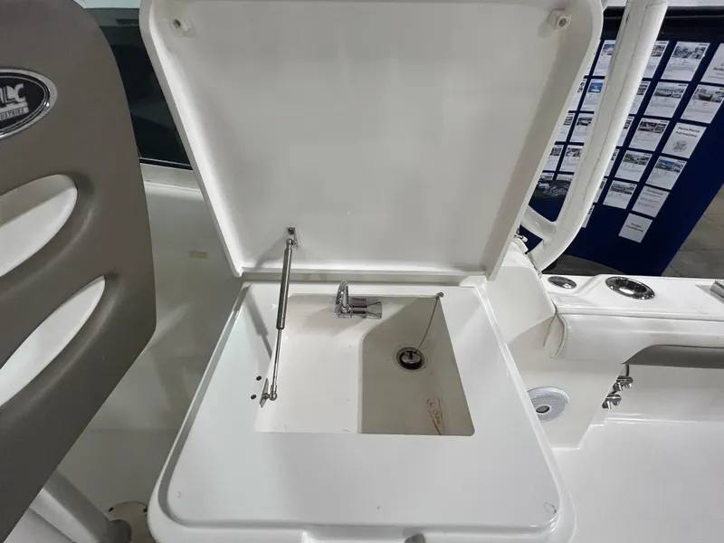 Slide: The Image of 2019 Albemarle 27 Dual Console boat sink with open lid and faucet. - 19
