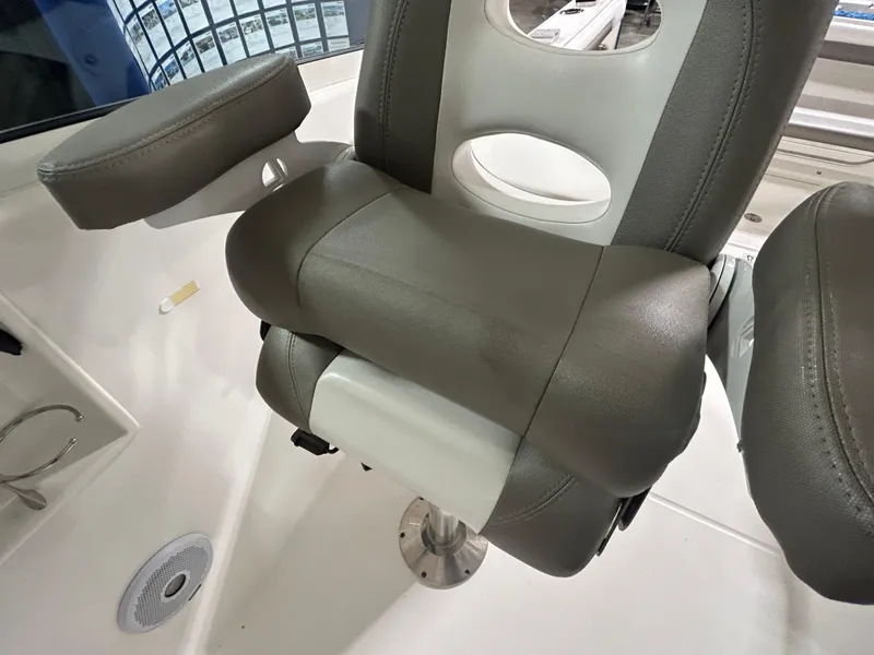 Slide: The Image of 2019 Albemarle 27 Dual Console boat seat with armrest, featuring gray and white upholstery. - 22