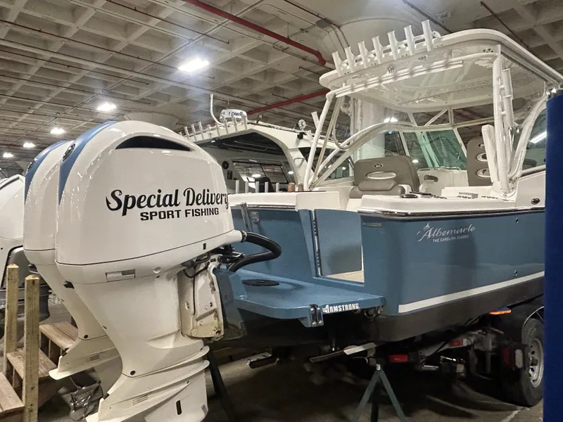 Slide: The Image of 2019 Albemarle 27 Dual Console boat with "Special Delivery Sport Fishing" motor in a warehouse. - 4