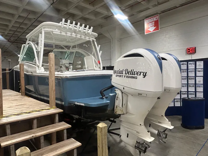 Slide: The Image of 2019 Albemarle 27 Dual Console boat with twin outboard motors in an indoor display. - 6