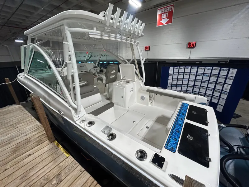 Slide: The Image of 2019 Albemarle 27 Dual Console boat displayed indoors, showcasing seating and controls. - 7