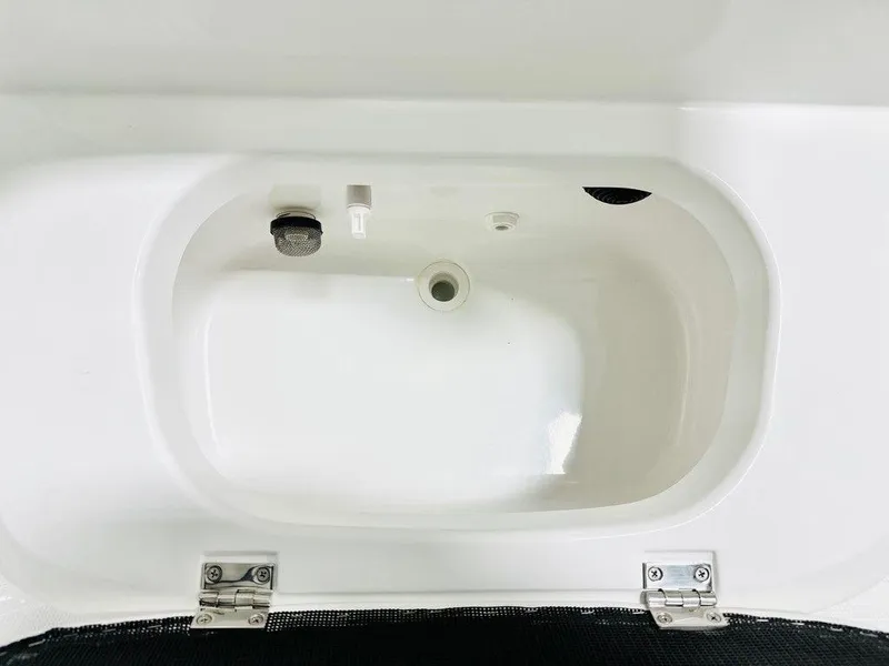 Slide: The Image of 2025 Frontier 2104 boat livewell with white interior and drainage system. - 6
