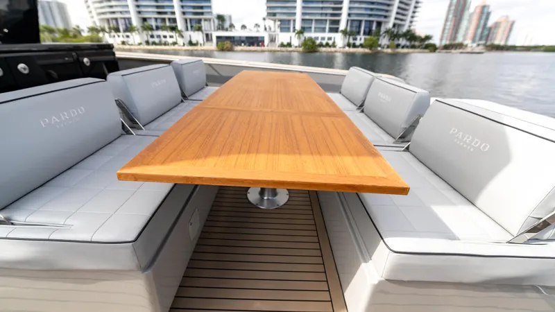 Slide: The Image of Luxury seating area on 2024 Pardo Yachts 43, featuring elegant wooden table and cushioned benches. - 18