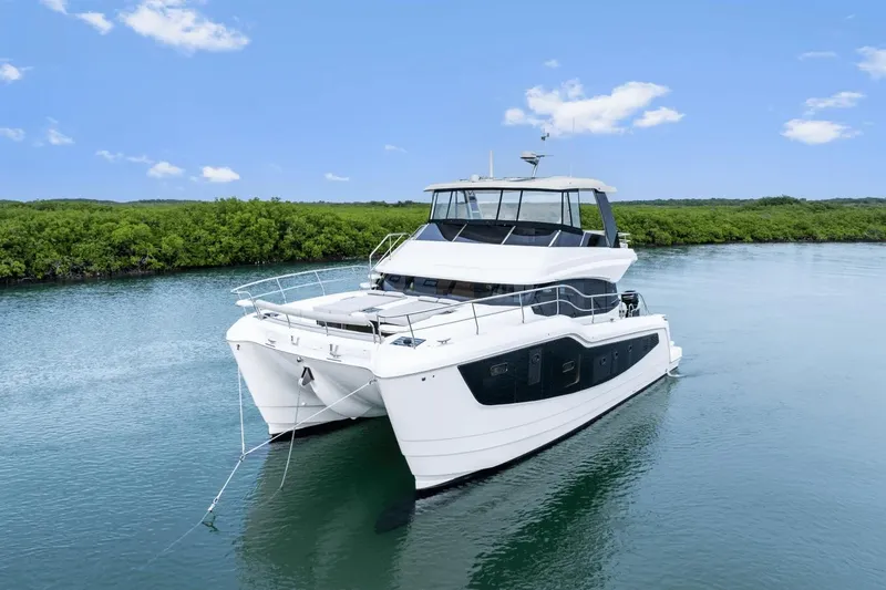 Slide: The Image of 2026 Aquila 50 Yacht cruising on a serene waterway with lush greenery. - 5