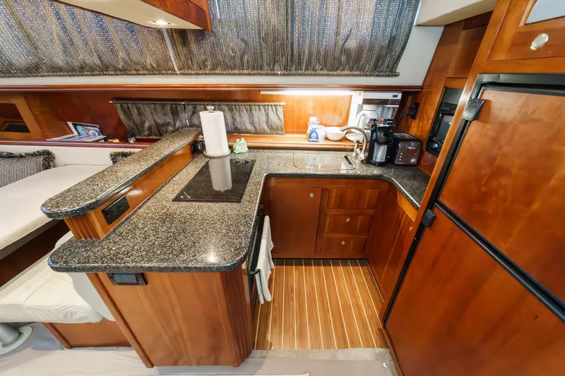 Slide: The Image of Luxurious 2006 Cruisers 415 yacht kitchen with wood cabinetry and granite countertops. - 21