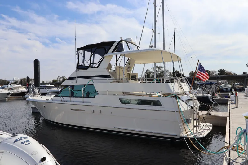 Slide: The Image of 1990 Hatteras 40 Double Cabin yacht docked at marina with American flag. - 0