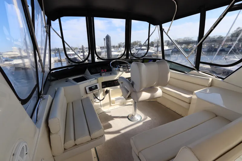 Slide: The Image of 1990 Hatteras 40 Double Cabin interior with helm, seating, and panoramic windows. - 17