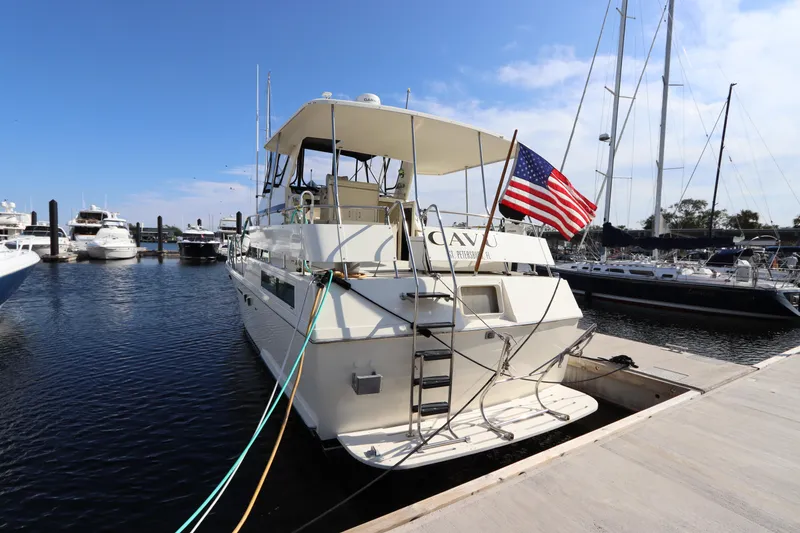 Slide: The Image of 1990 Hatteras 40 Double Cabin yacht docked at marina with American flag. - 2