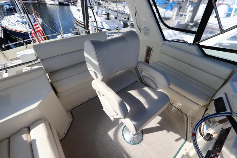 Slide: The Image of 1990 Hatteras 40 Double Cabin interior with plush seating and helm chair. - 21
