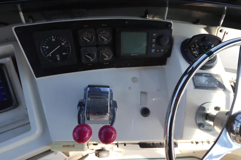 Slide: The Image of 1990 Hatteras 40 Double Cabin helm with gauges, controls, and steering wheel. - 25